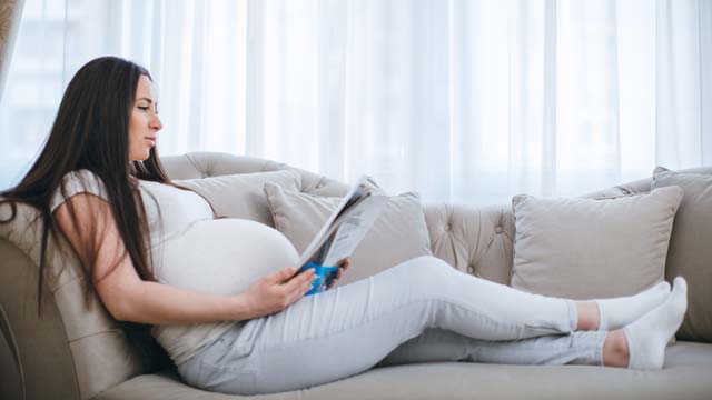 Pregnant woman reading newsletter