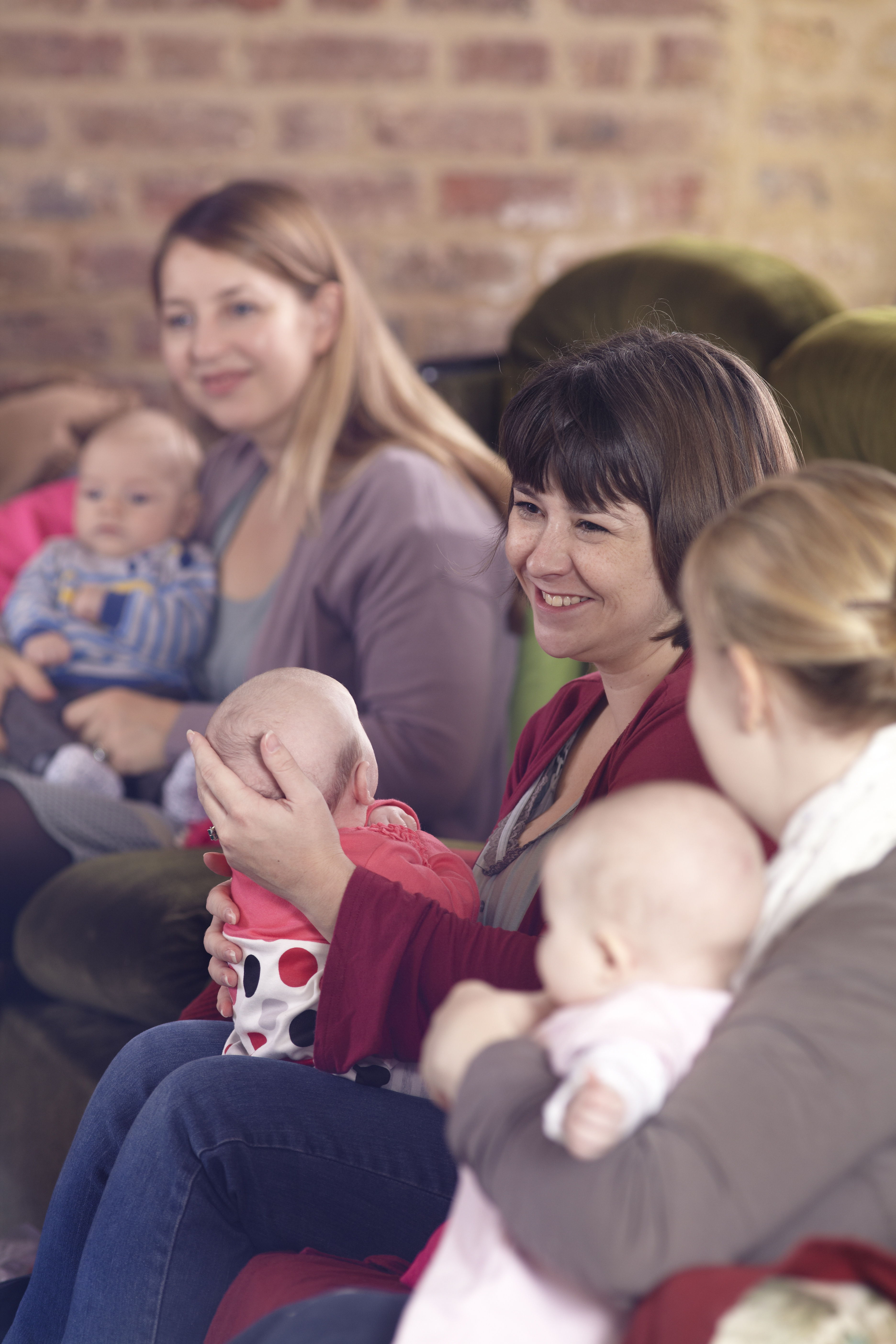 A row of women talking and holding their babies