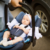 dad carrying baby in car seat 