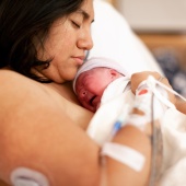 Parent recovering in bed after birth with baby