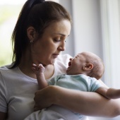 Parent holding a crying baby and looking concerned