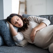 Pregnant parent lying on sofa