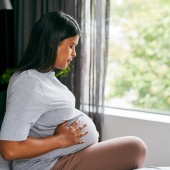 Pregnant woman or person sitting on the bed