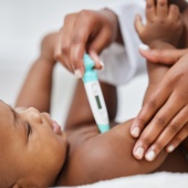Baby having temperature taken with thermometer