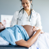 Doctor examining pregnant woman or birthing person