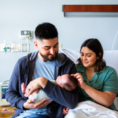Parents holding newborn baby in hospital