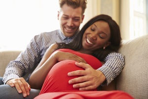 Pregnant couple smiling and talking
