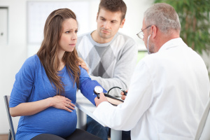 Pregnant woman with partner at doctors