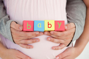 woman holding blocks that read baby
