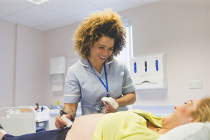 midwife giving pregnant woman an ultrasound