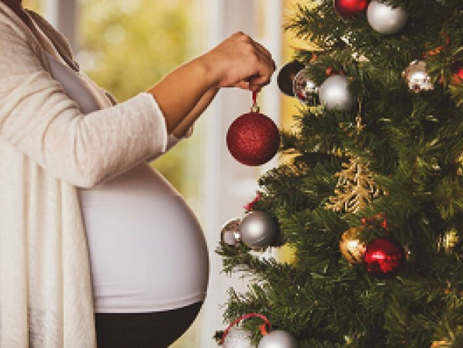 Pregnant lady decorating christmas tree
