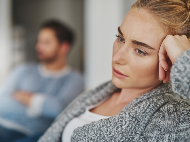 Woman sitting on a sofa next to her partner