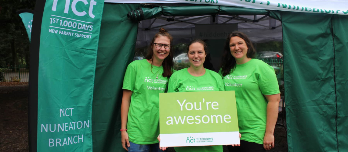 Three volunteers holding You're awesome sign