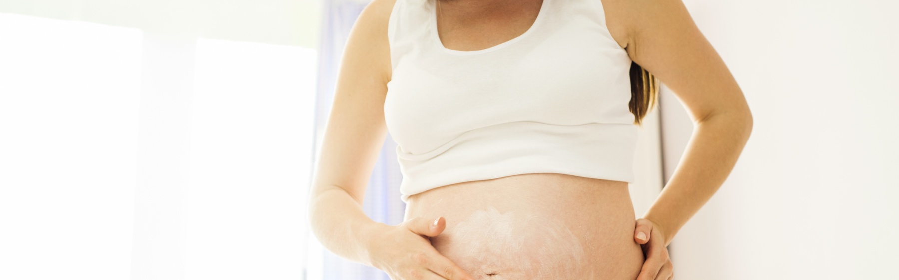 Pregnant person applying moisturiser