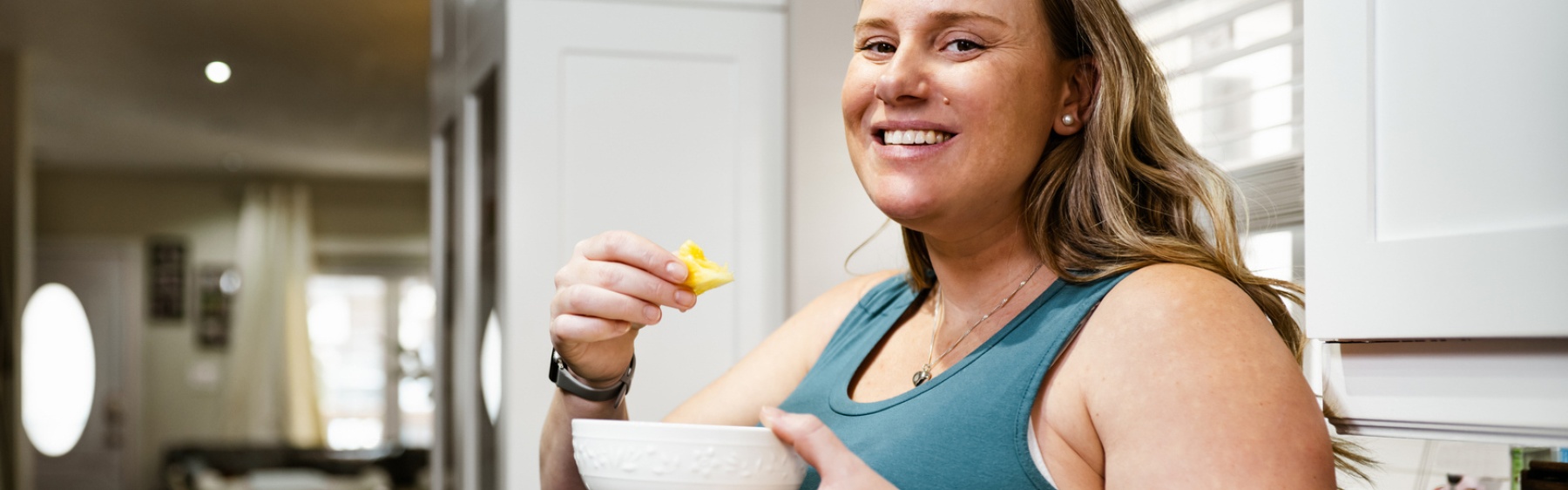 Pregnant parent eating in kitchen