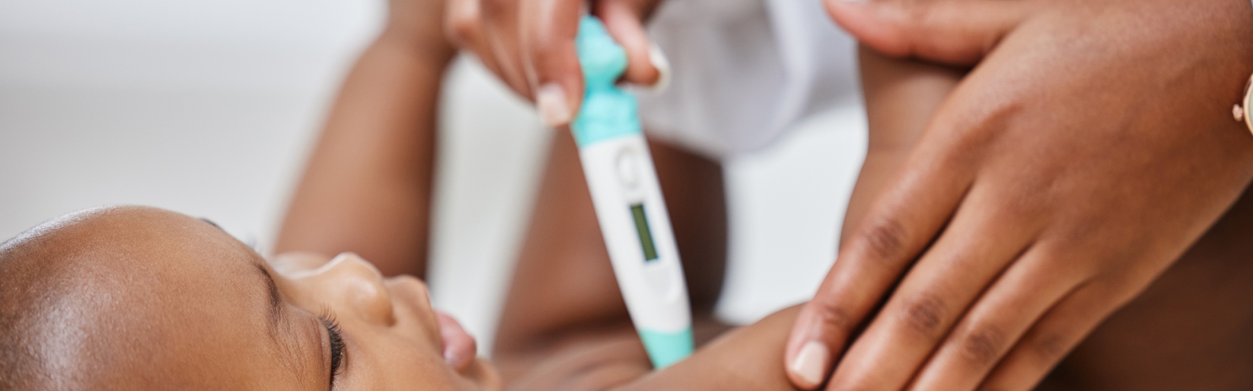 Baby having temperature taken with a thermometer