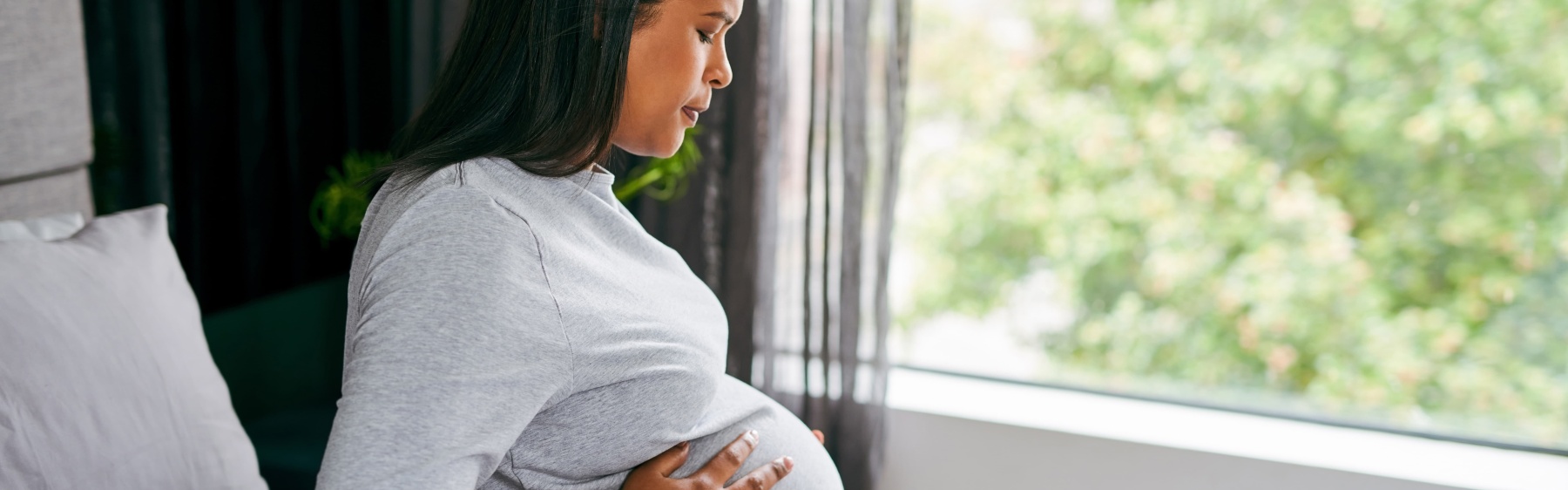 Pregnant woman or person sitting on the bed