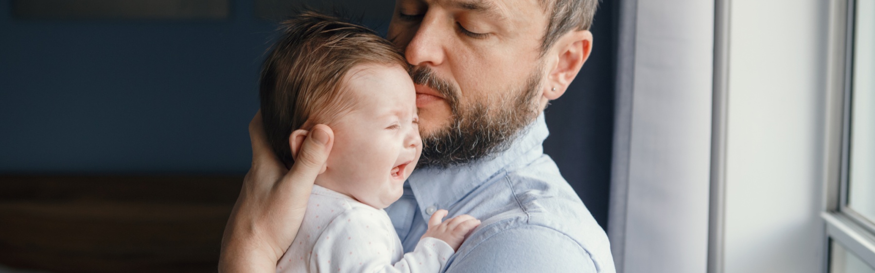 Parent holding crying baby