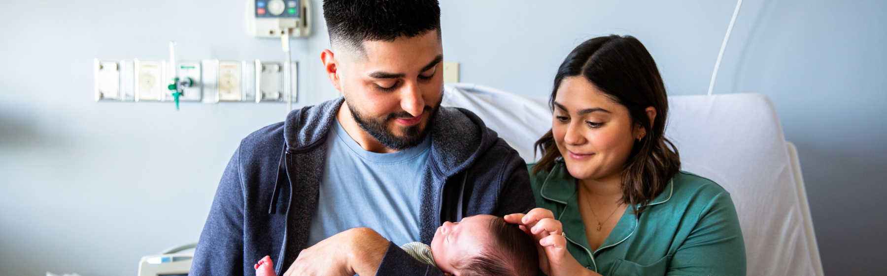 Parents holding newborn baby in hospital