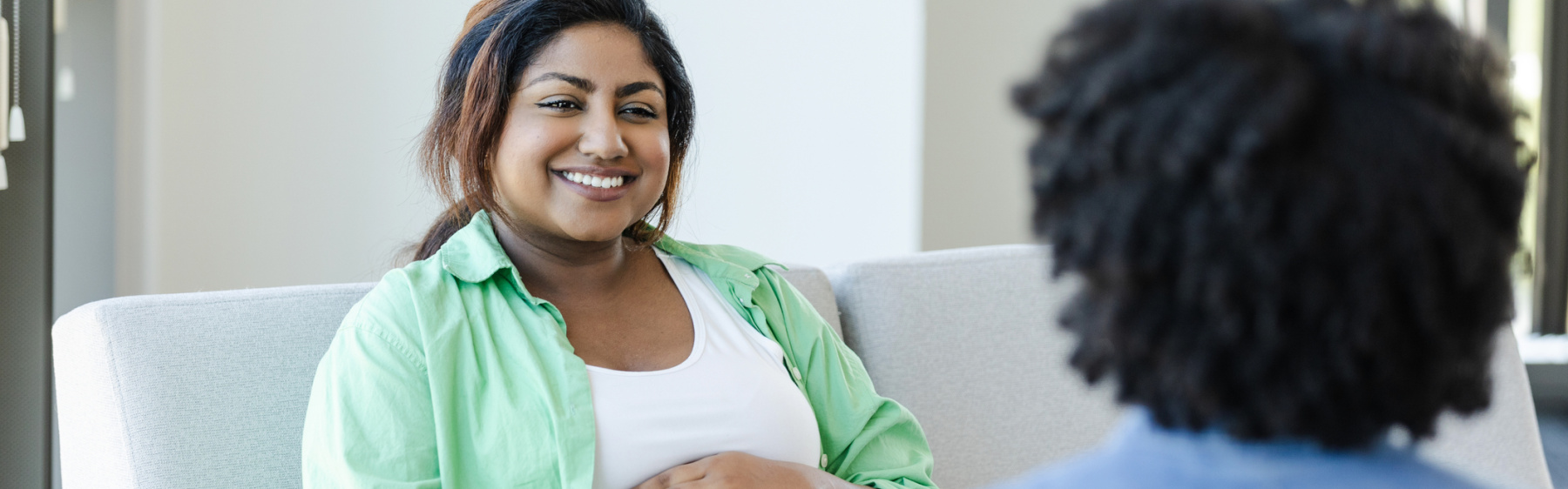 Pregnant woman or birthing person talking to midwife