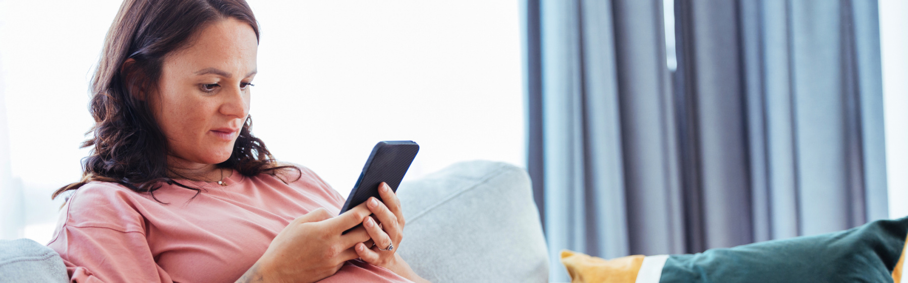 Pregnant woman or birthing person looking at phone