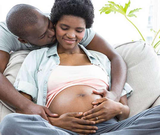 Pregnant couple on couch