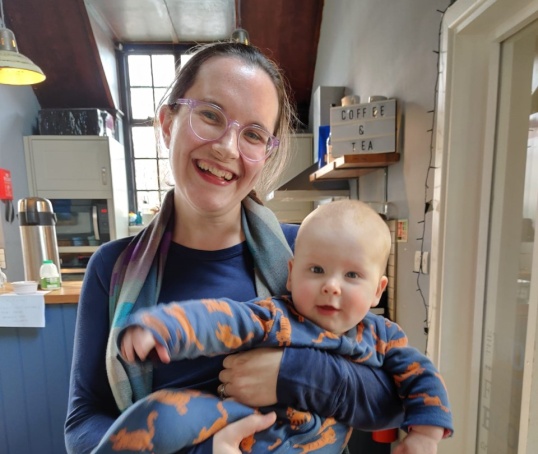 Newham mother holding baby in a cafe