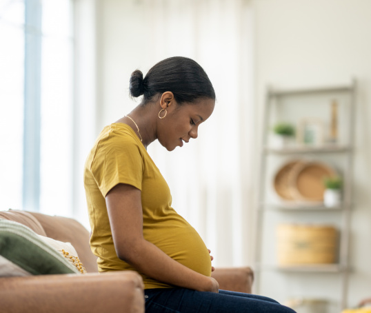 Pregnant parent looking at her bump