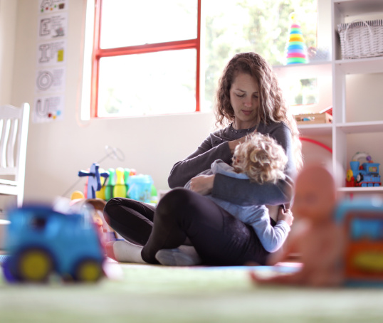 Parent breastfeeding child in playroom