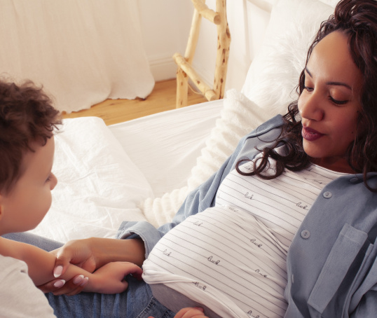 Pregnant woman lying down with toddler