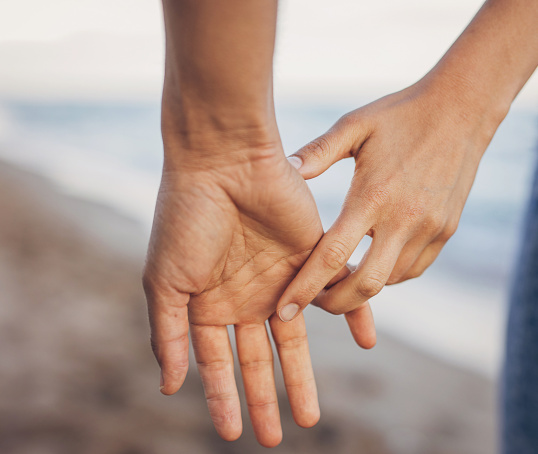 Couple holding hands on beach
