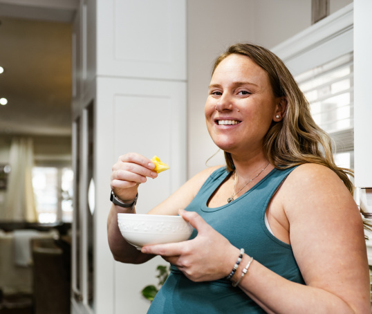 Pregnant parent eating in kitchen