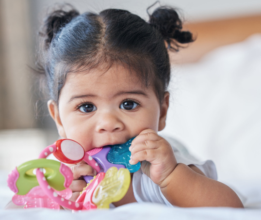 Young baby chewing teething ring