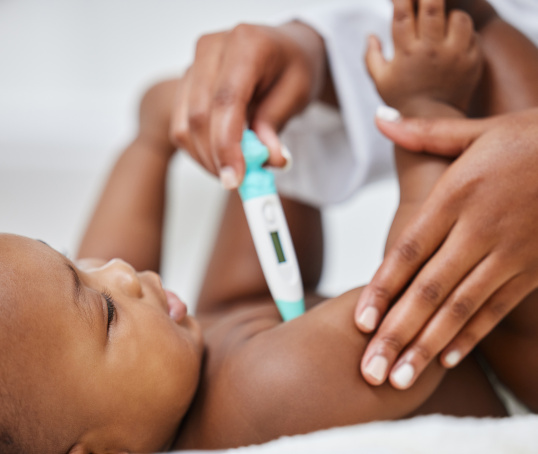 Baby having temperature taken with a thermometer