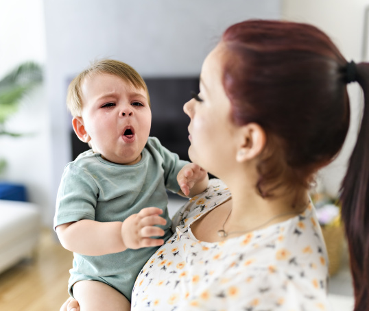 Parent holding a coughing baby