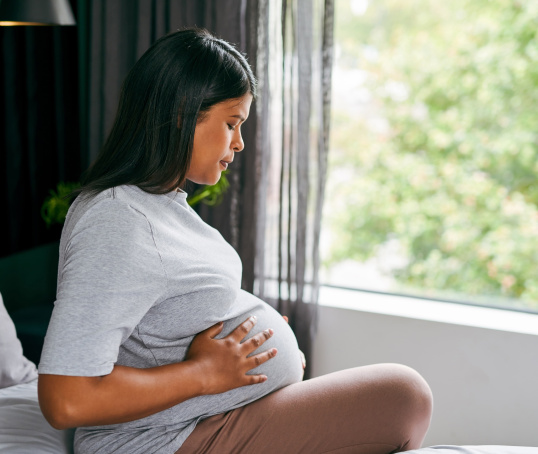 Pregnant woman or person sitting on the bed