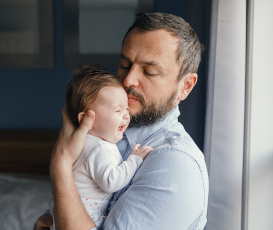 Parent holding crying baby