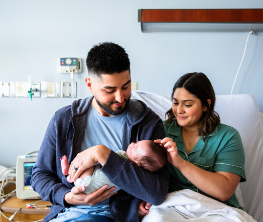 Parents holding newborn baby in hospital