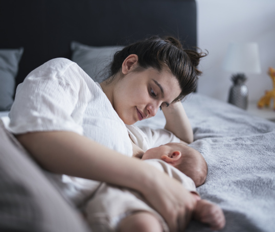 Mother or birthing person in bed with baby