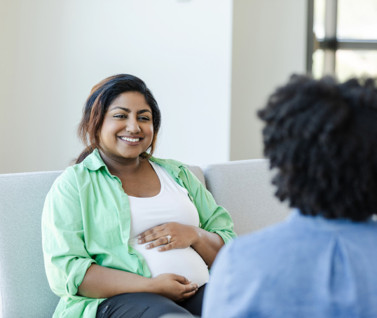 Pregnant woman or birthing person talking to midwife
