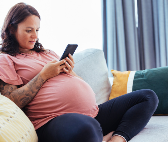 Pregnant woman or birthing person looking at phone