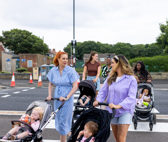 Parents pushing buggies on a group walk