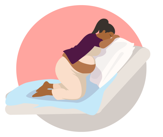 Woman or birthing person kneeling over the back of the bed