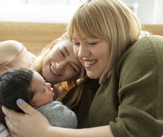 Parents with baby on bed