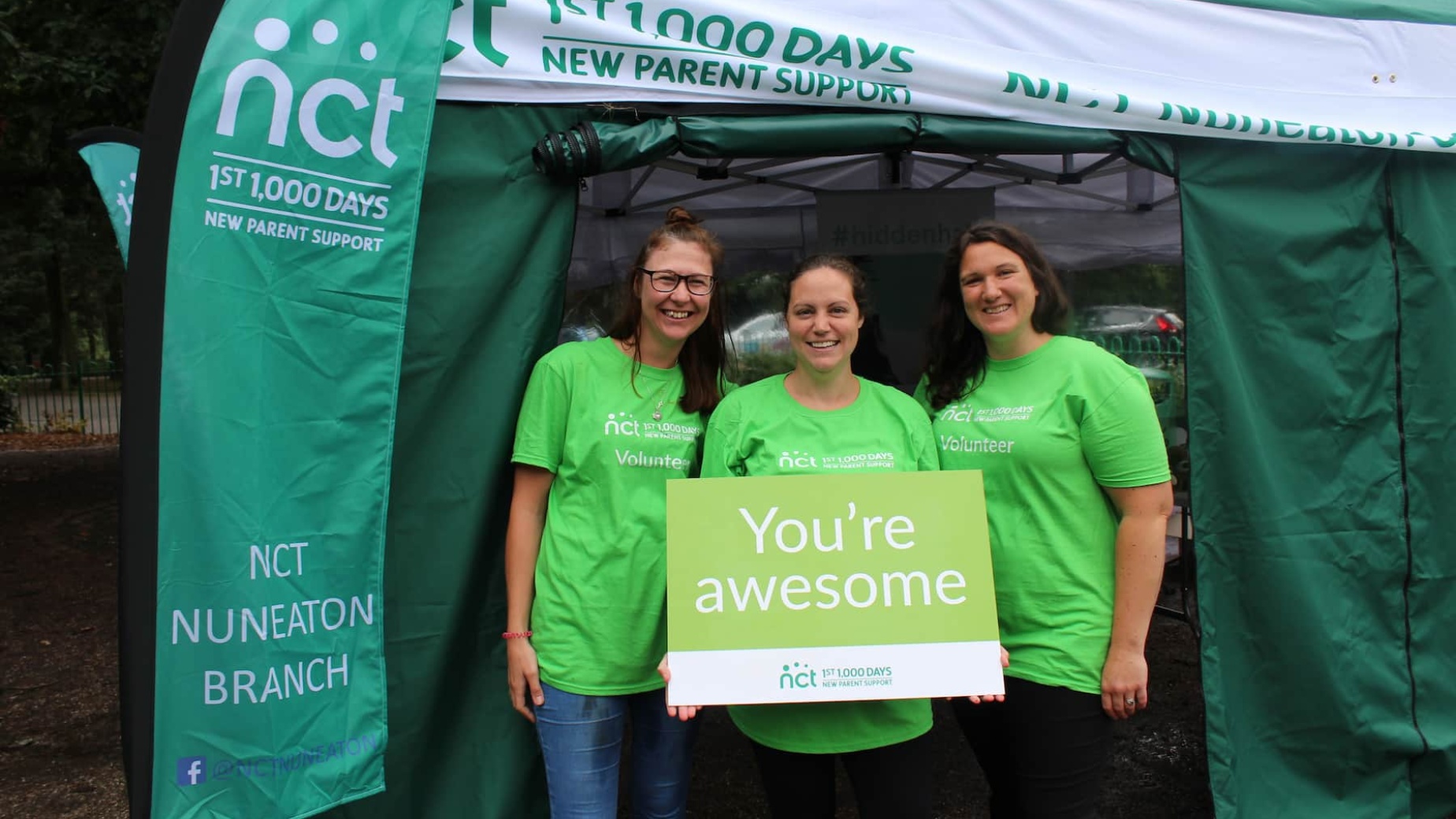 Three volunteers holding You're awesome sign