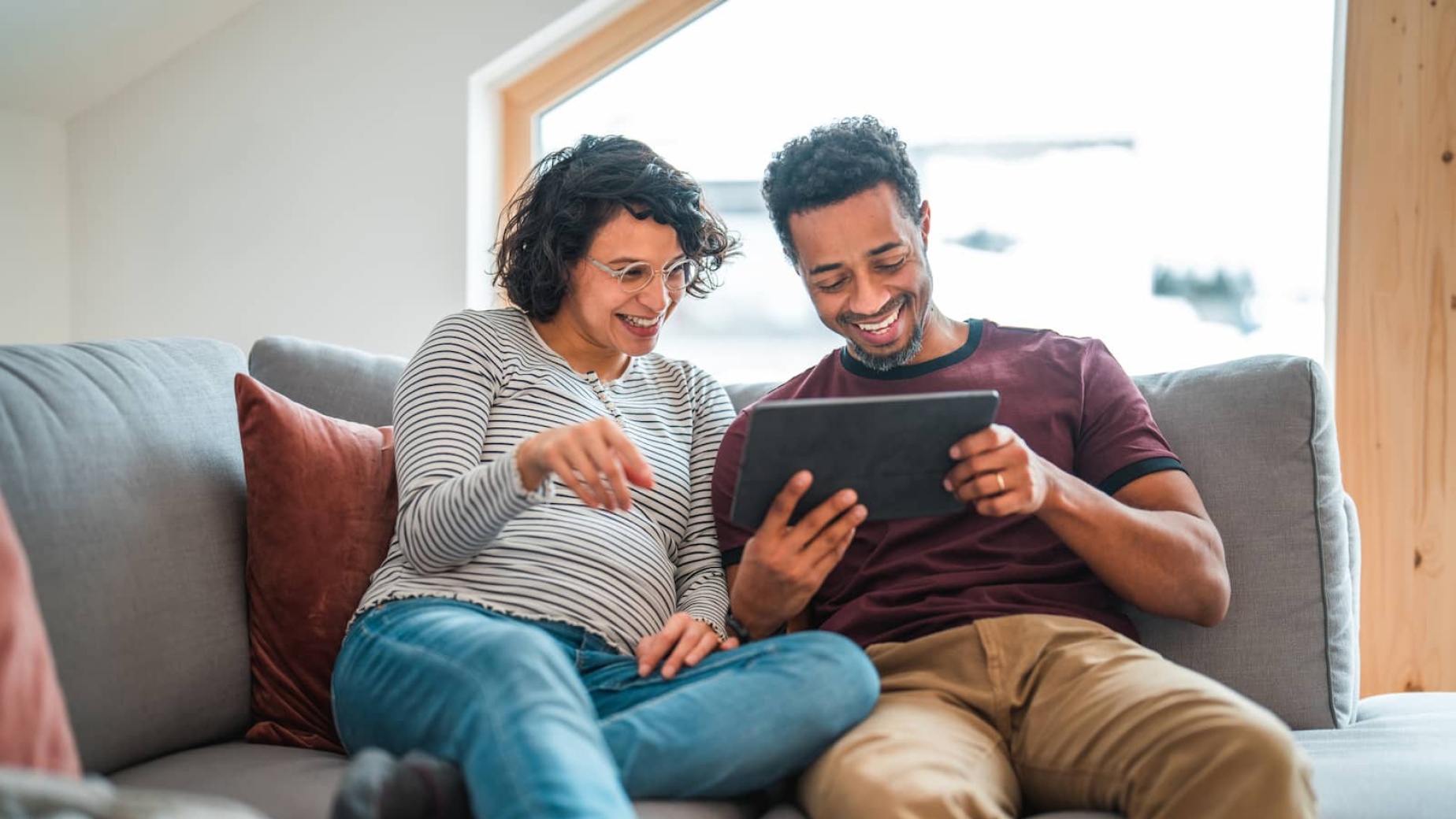 Pregnant couple on video call on a tablet device