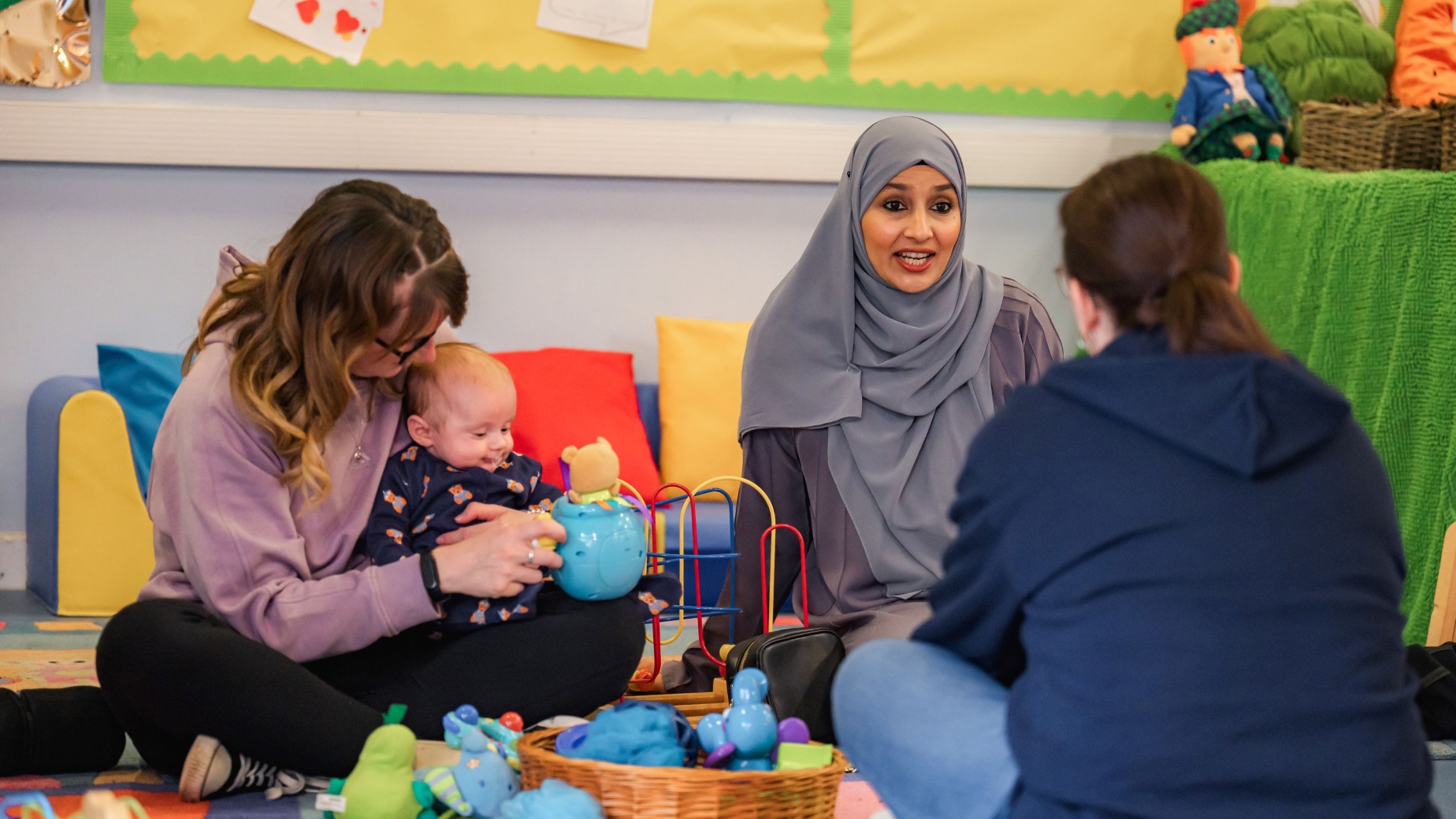 Peer supporter talking with mother and baby