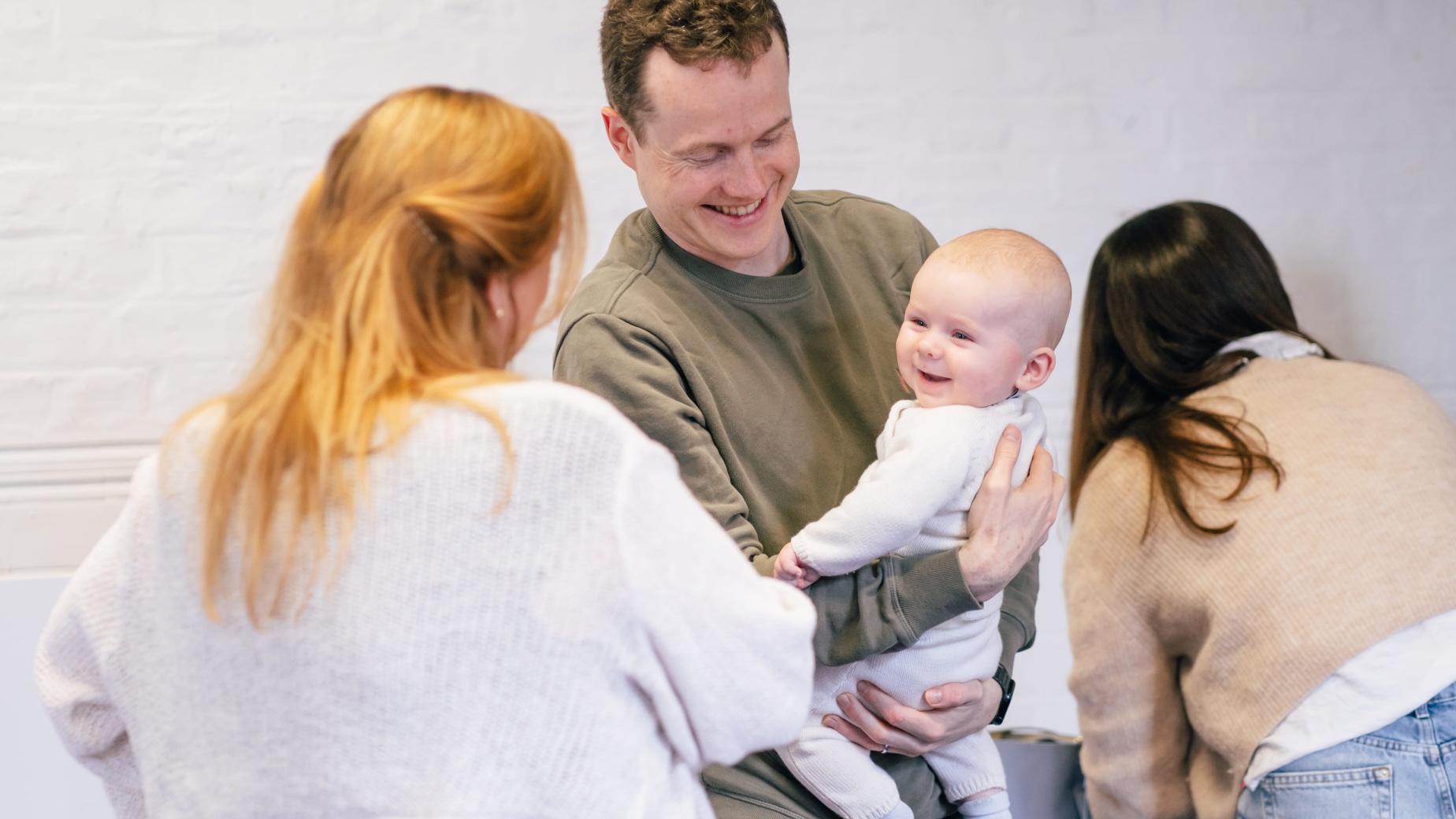 Dad holding baby with NCT New Baby course practitioner