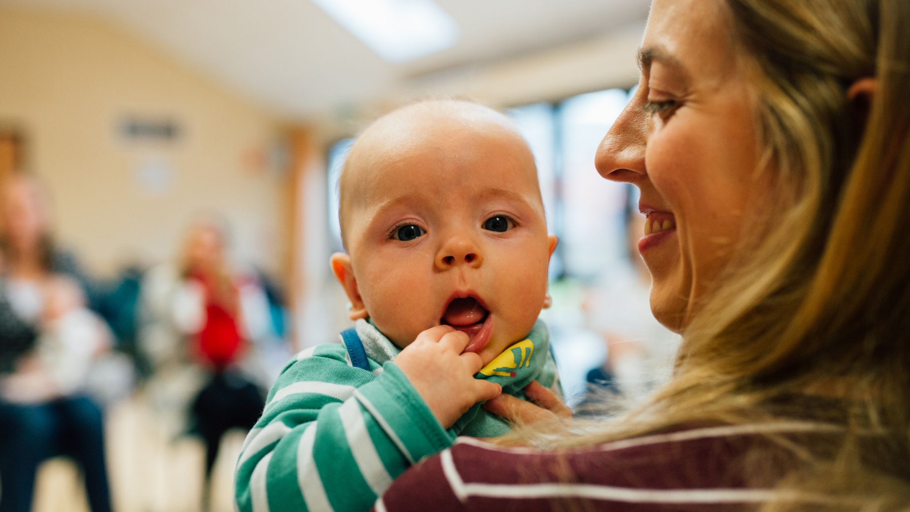 Baby looking over mum's shoulder during a postnatal group