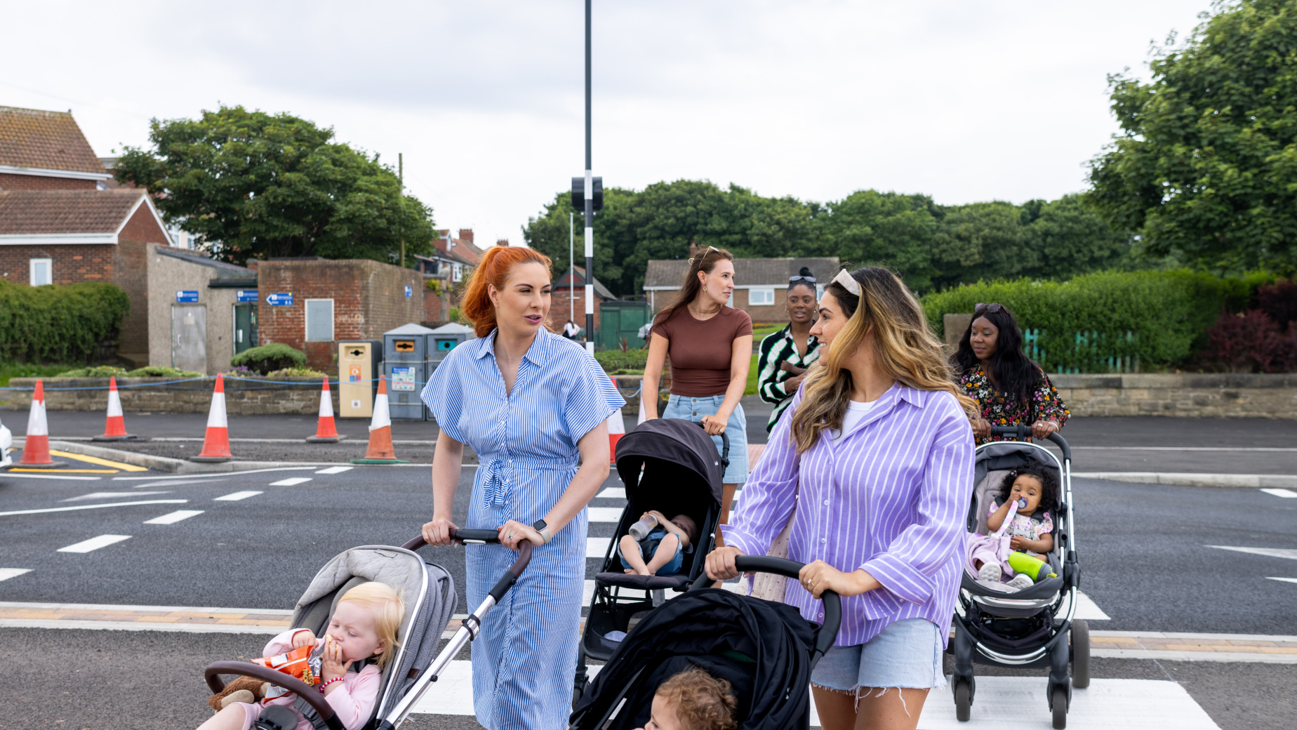 Parents pushing buggies on a group walk